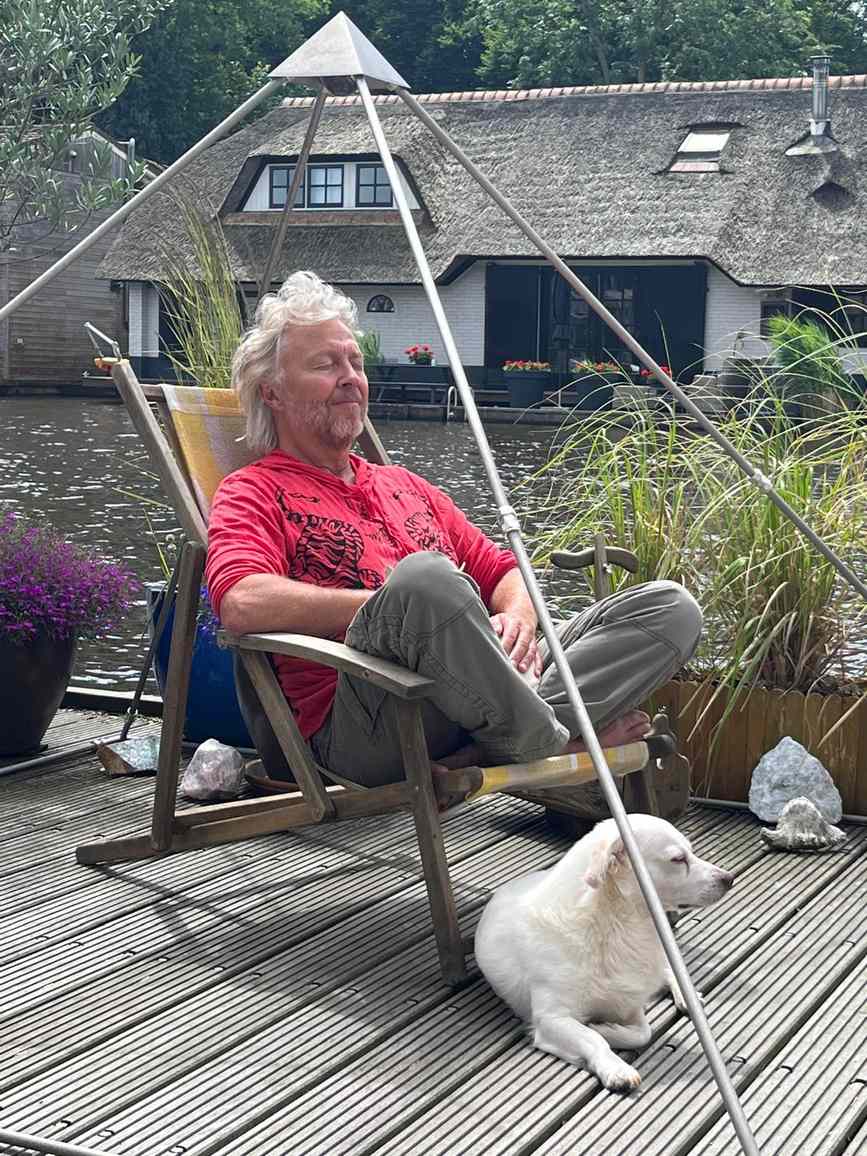 Man relaxing with his dog inside the Phipower meditation pyramid